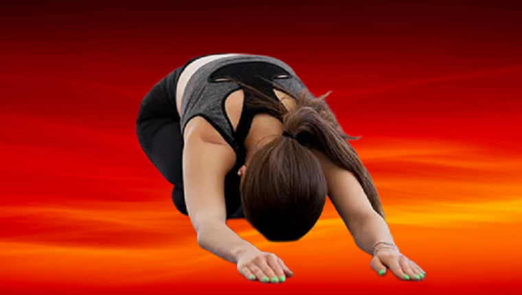 Kvinde på knæ på måtte med varm baggrund