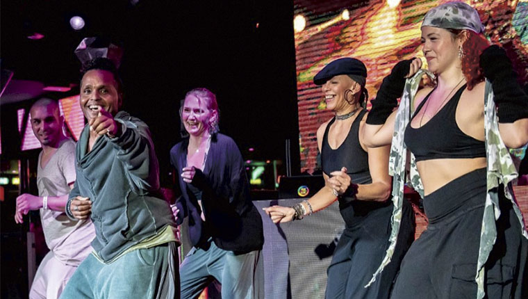 Multietnisk gruppe danser på scene