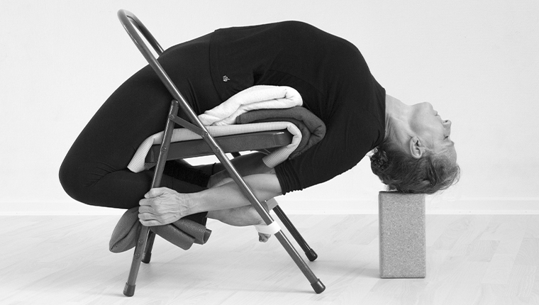 Ananda Yoga - Hanne viser bagudbøjet yogaøvelse med stol